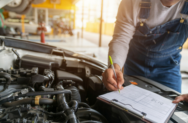 car mechanic checking under car bonnet